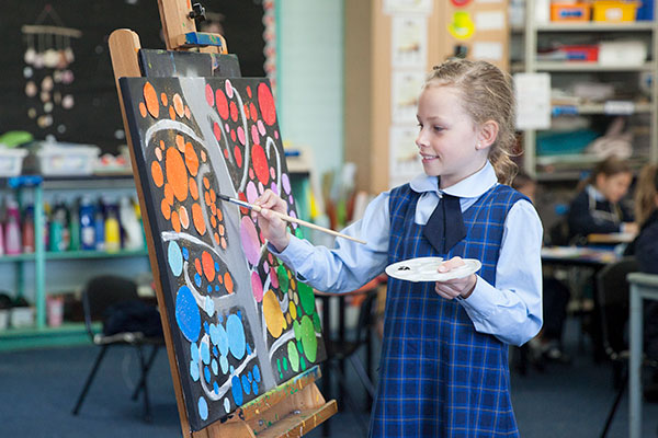 St Agnes Catholic Primary School Matraville student putting finishing touches on a painting